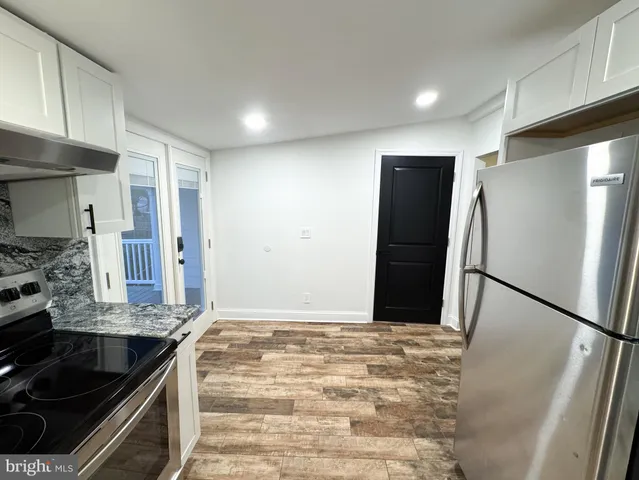 a kitchen with granite countertop a refrigerator and a sink