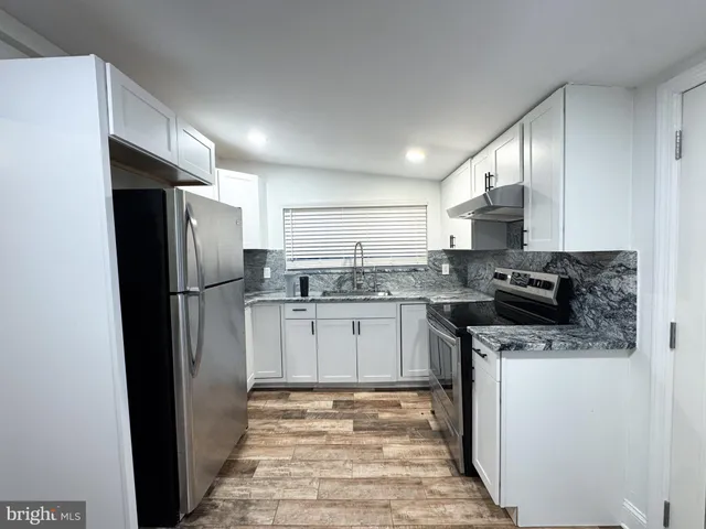 a kitchen with a refrigerator sink and cabinets