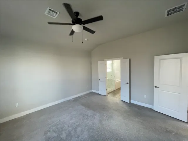 an empty room with a ceiling fan and window