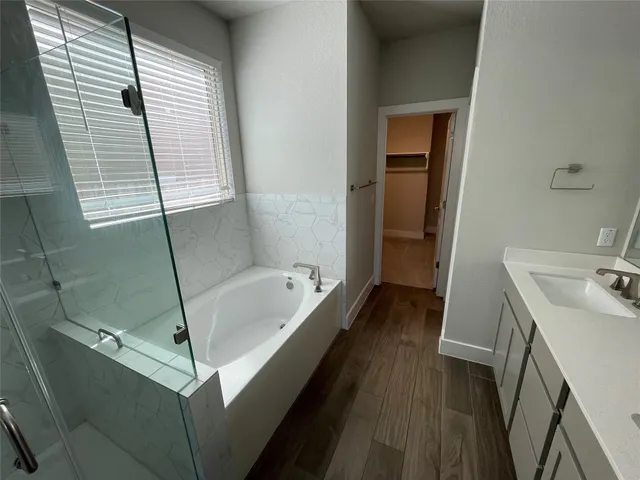 a bathroom with a tub sink toilet and a window