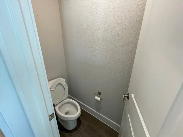 an empty room with wooden floor fan and window