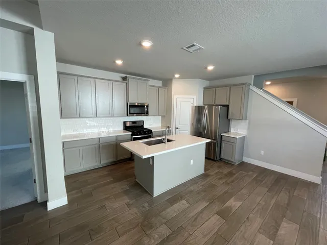 a kitchen with a refrigerator and a stove top oven