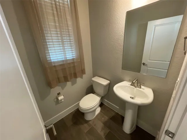 a bathroom with a sink toilet and a mirror