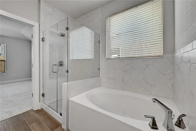 a white bath tub sitting next to a shower