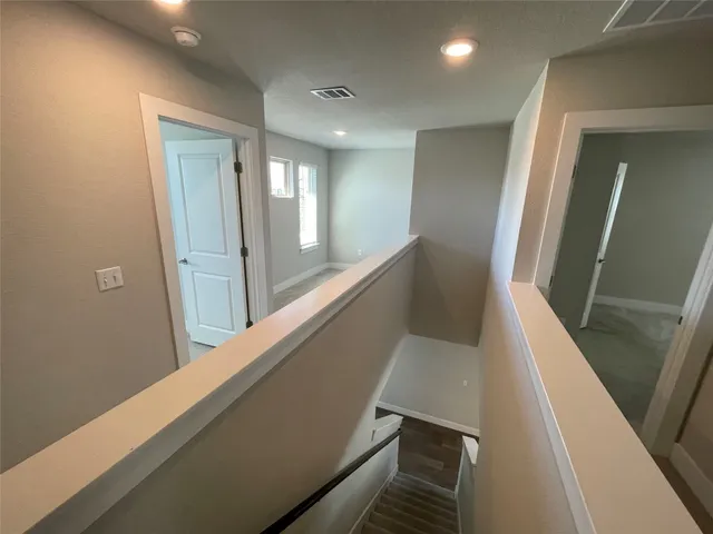 a view of a hallway with wooden floor and staircase