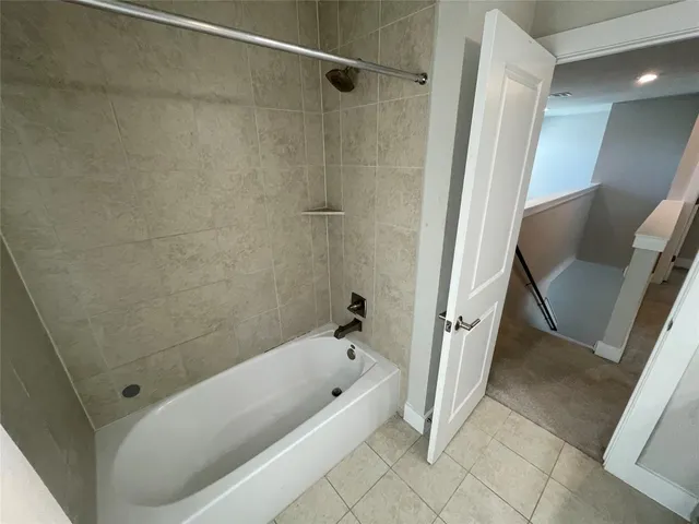 a bathroom with a tub a toilet and a shower