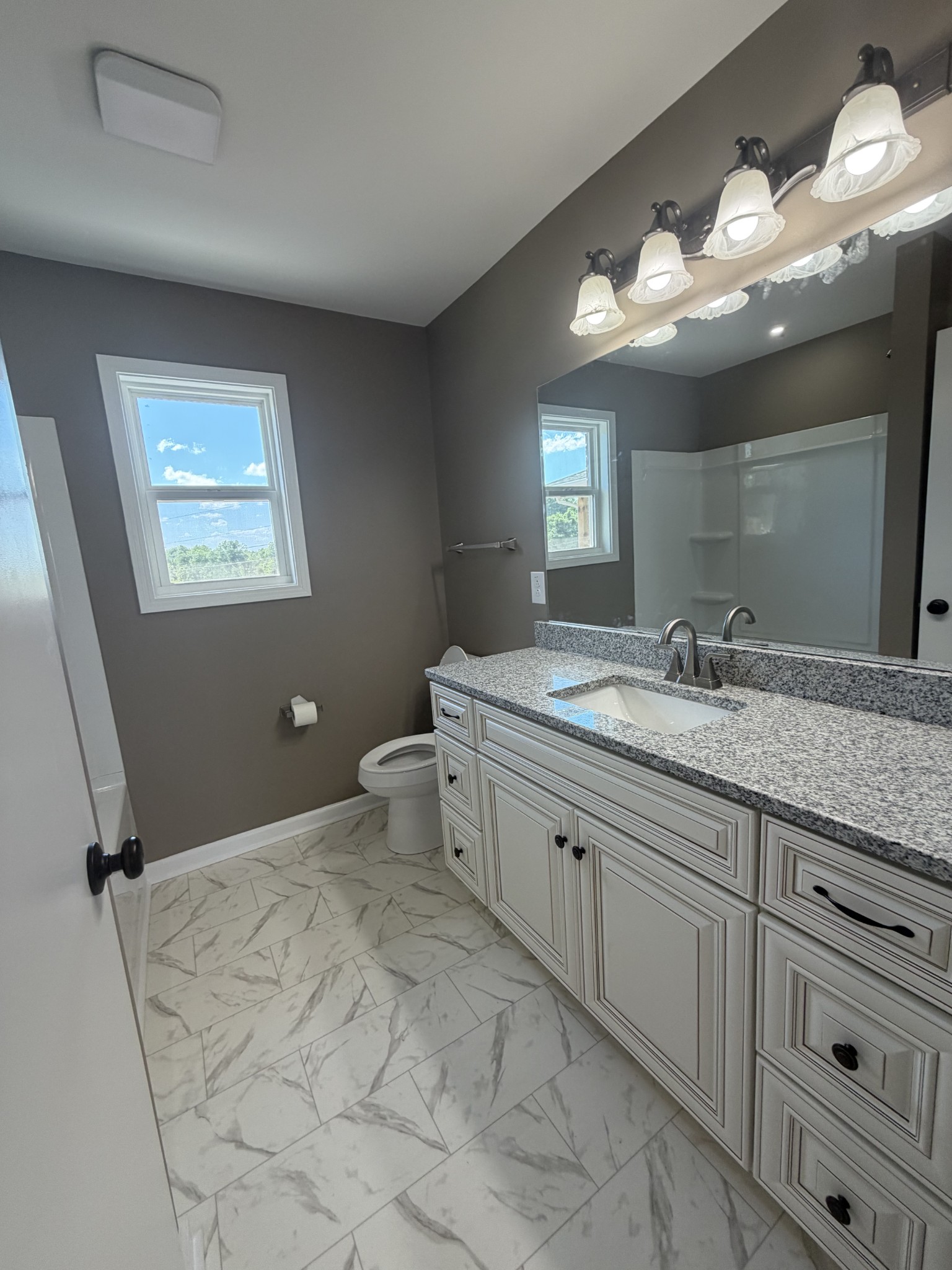 2280 Graham Cemetery Road Clarksville, TN 37043 - Photo 17 of 19 a spacious bathroom with a granite countertop sink a toilet and a mirror