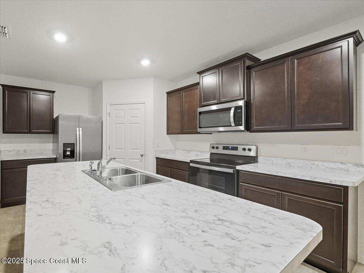 352 Catfish Place Cocoa, FL 32927 - Photo 16 of 30 a kitchen with stainless steel appliances granite countertop a sink stove microwave and refrigerator