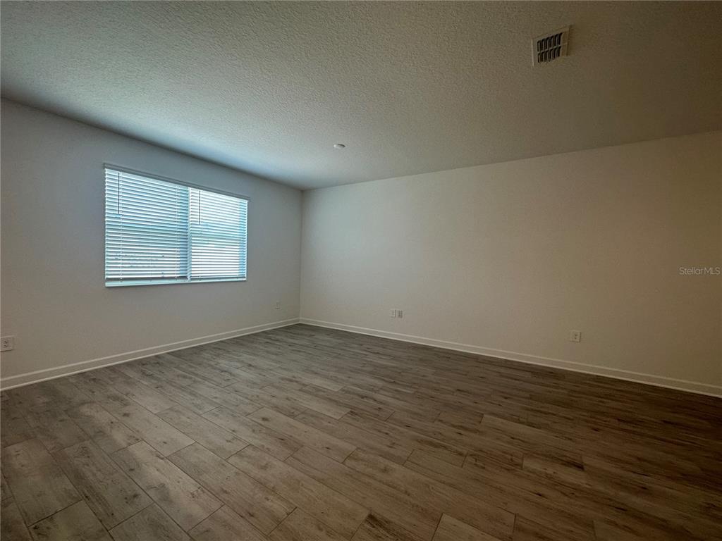 3128 Addison Boulevard St. Cloud, FL 34771 - Photo 11 of 35 an empty room with wooden floor and windows