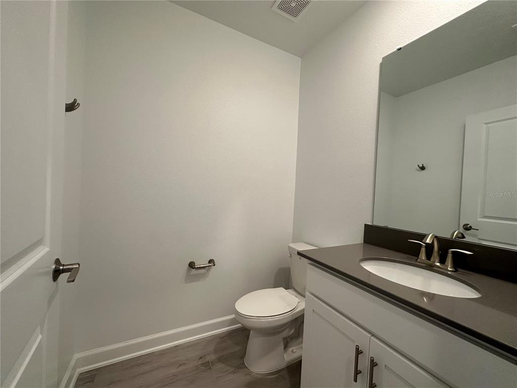 3128 Addison Boulevard St. Cloud, FL 34771 - Photo 12 of 35 a bathroom with a granite countertop sink toilet and a mirror