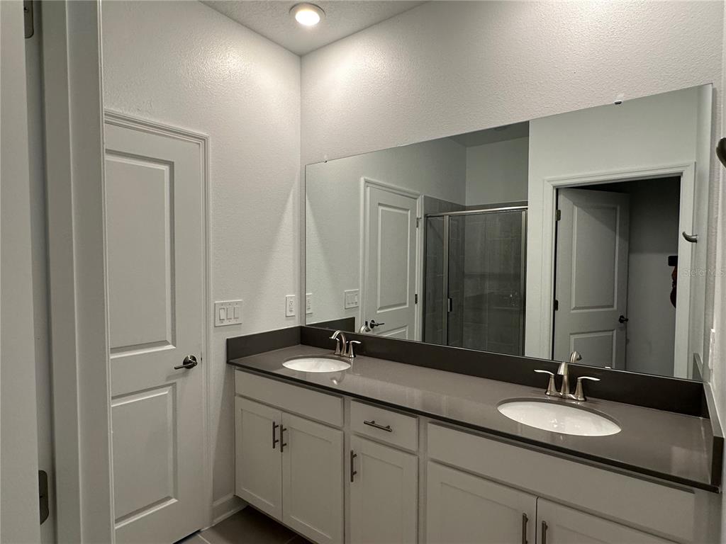 3128 Addison Boulevard St. Cloud, FL 34771 - Photo 14 of 35 a bathroom with a granite countertop sink and a mirror