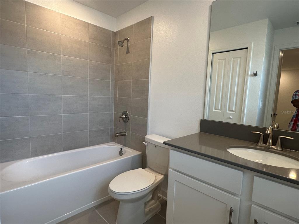 3128 Addison Boulevard St. Cloud, FL 34771 - Photo 17 of 35 a bathroom with a sink toilet a mirror and bathtub