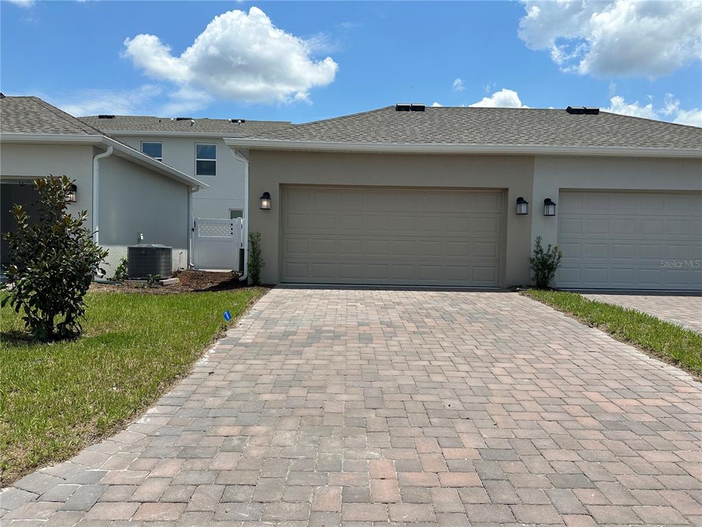 3128 Addison Boulevard St. Cloud, FL 34771 - Photo 2 of 35 a front view of a house with a yard and garage
