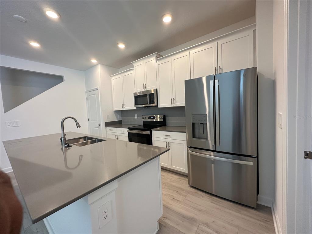 3128 Addison Boulevard St. Cloud, FL 34771 - Photo 6 of 35 a kitchen with stainless steel appliances a refrigerator sink and microwave