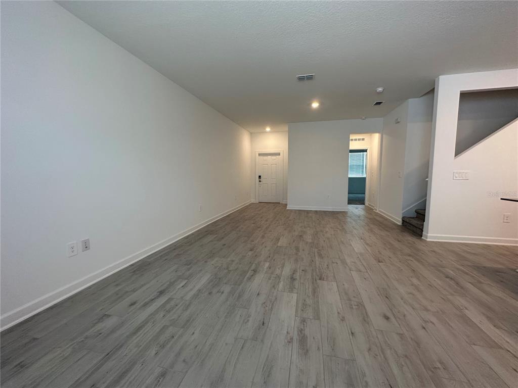 3128 Addison Boulevard St. Cloud, FL 34771 - Photo 9 of 35 an empty room with wooden floor and windows