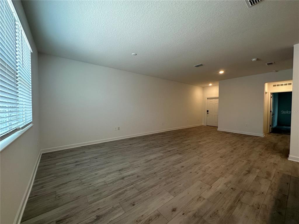 3128 Addison Boulevard St. Cloud, FL 34771 - Photo 10 of 35 an empty room with wooden floor and windows