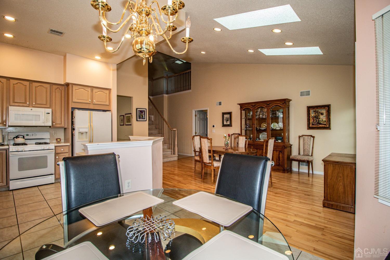 32 Harwood Road Monroe Township, NJ 08831 - Photo 12 of 34 a living room with couches chairs and kitchen view with wooden floor