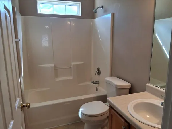 a white toilet sitting next to a bathroom sink