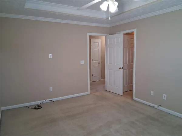 a view of an empty room with a chandelier fan