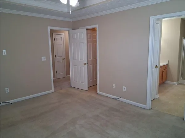 an empty room with closet and a chandelier fan