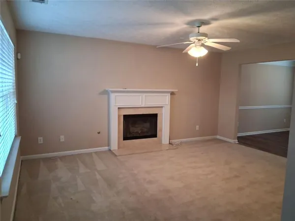 a view of an empty room with a chandelier fan