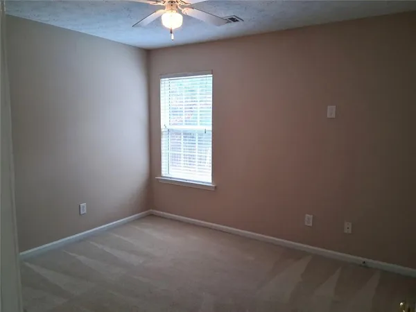 a view of an empty room with a chandelier fan