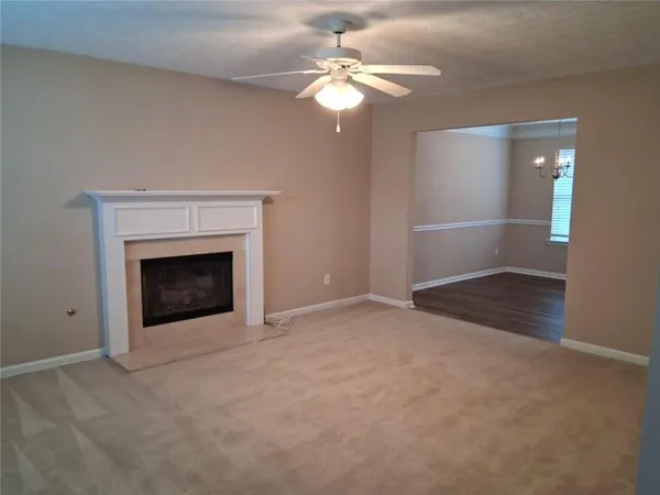 an empty room with fan and fireplace