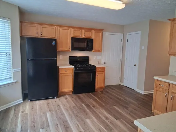 a kitchen with a refrigerator stove and wooden cabinets