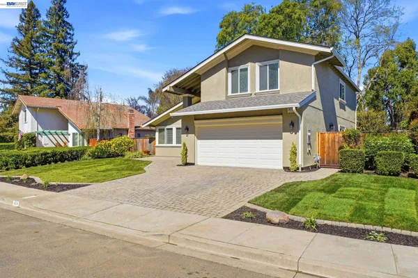 a front view of a house with a yard and green space