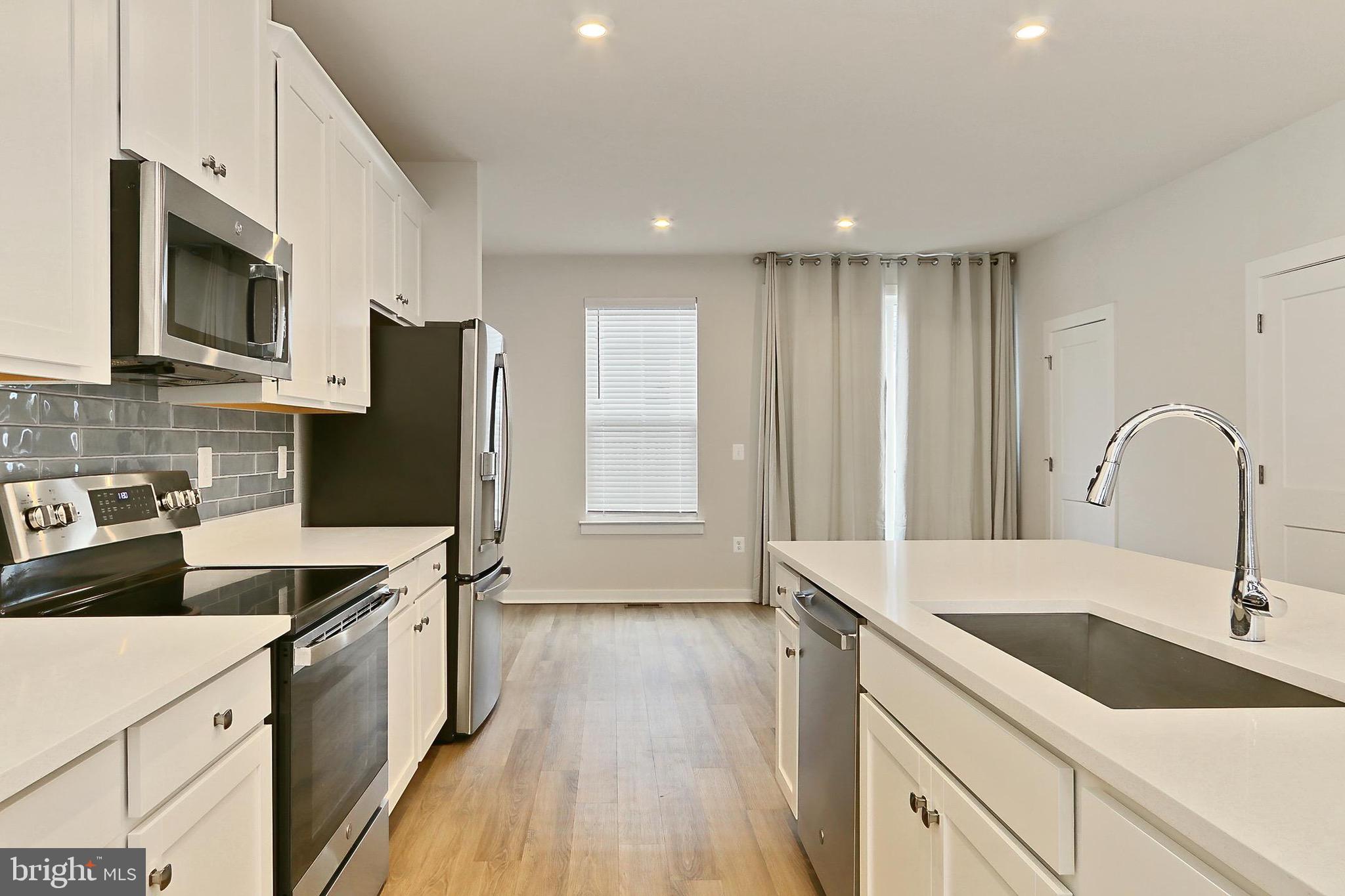 14176 Gypsum Loop Chantilly, VA 20151 - Photo 21 of 43 a kitchen with a sink wooden floor and stainless steel appliances