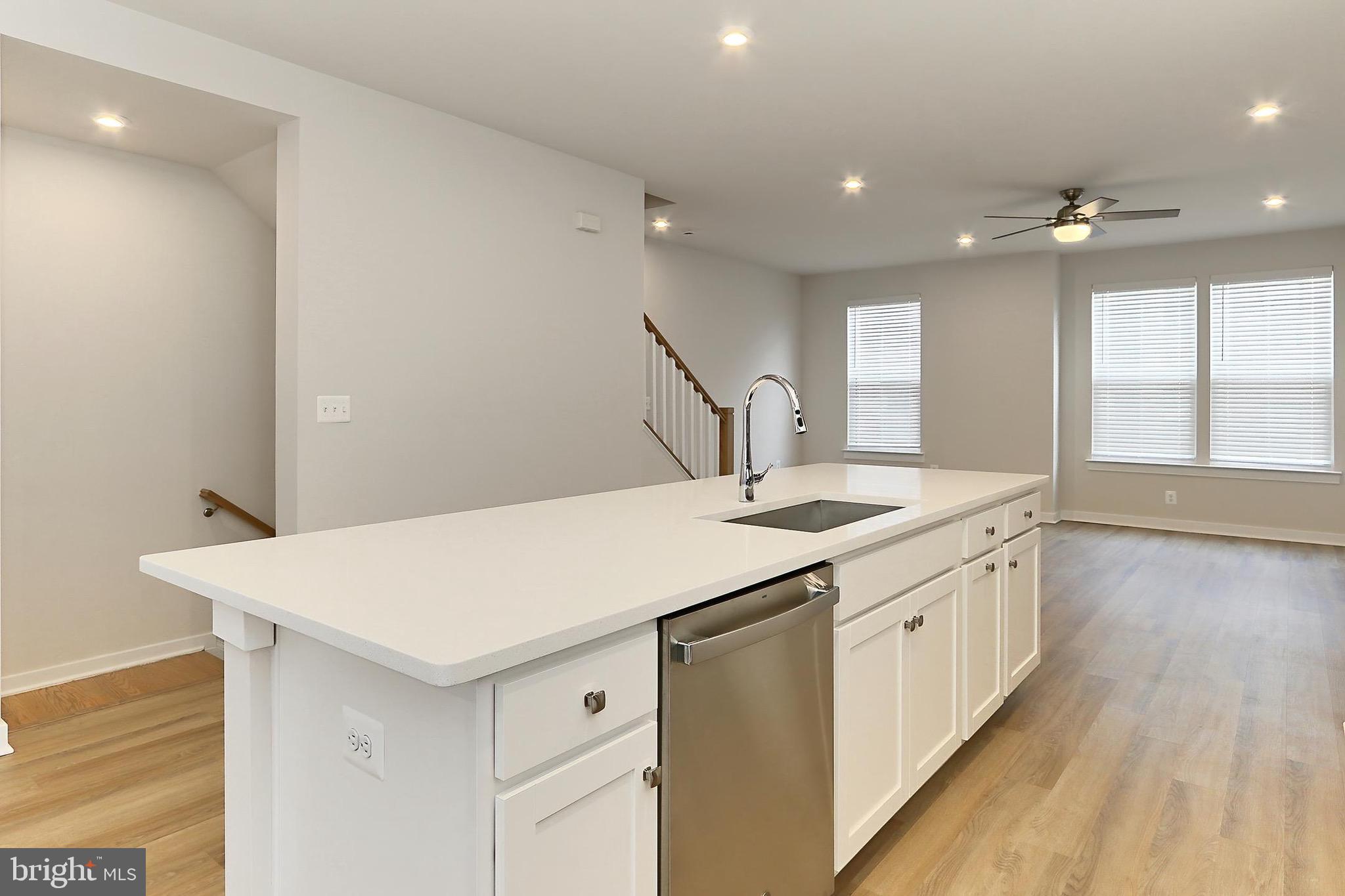 14176 Gypsum Loop Chantilly, VA 20151 - Photo 23 of 43 a kitchen with a sink a wooden floor and white walls