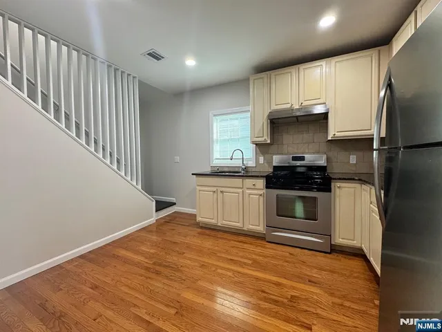 a kitchen with stainless steel appliances a stove a refrigerator and a sink