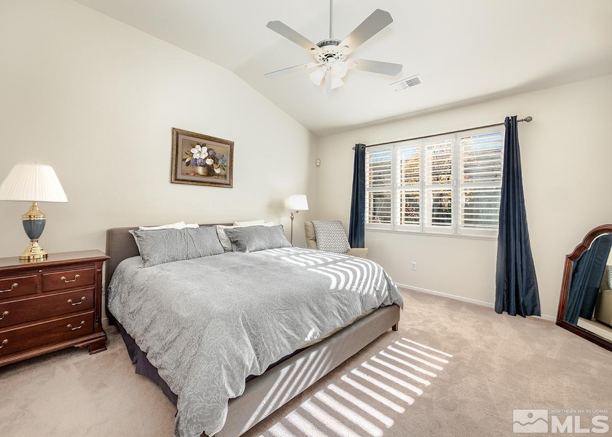 1408 Wild Wolf Way Reno, NV 89521 - Photo 14 of 24 a spacious bedroom with a bed a dresser and a window