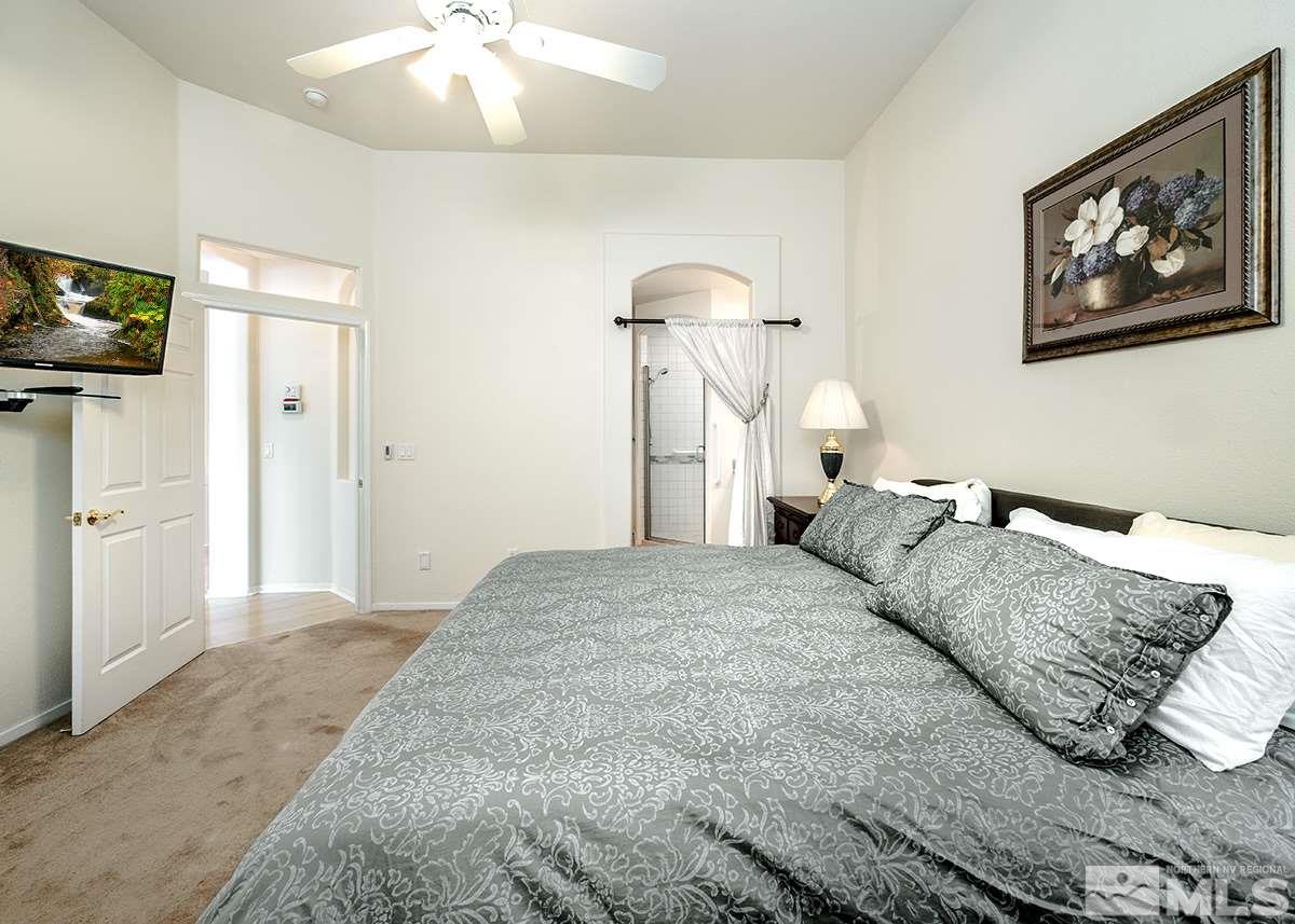 1408 Wild Wolf Way Reno, NV 89521 - Photo 15 of 24 a bedroom with a bed and a chandelier