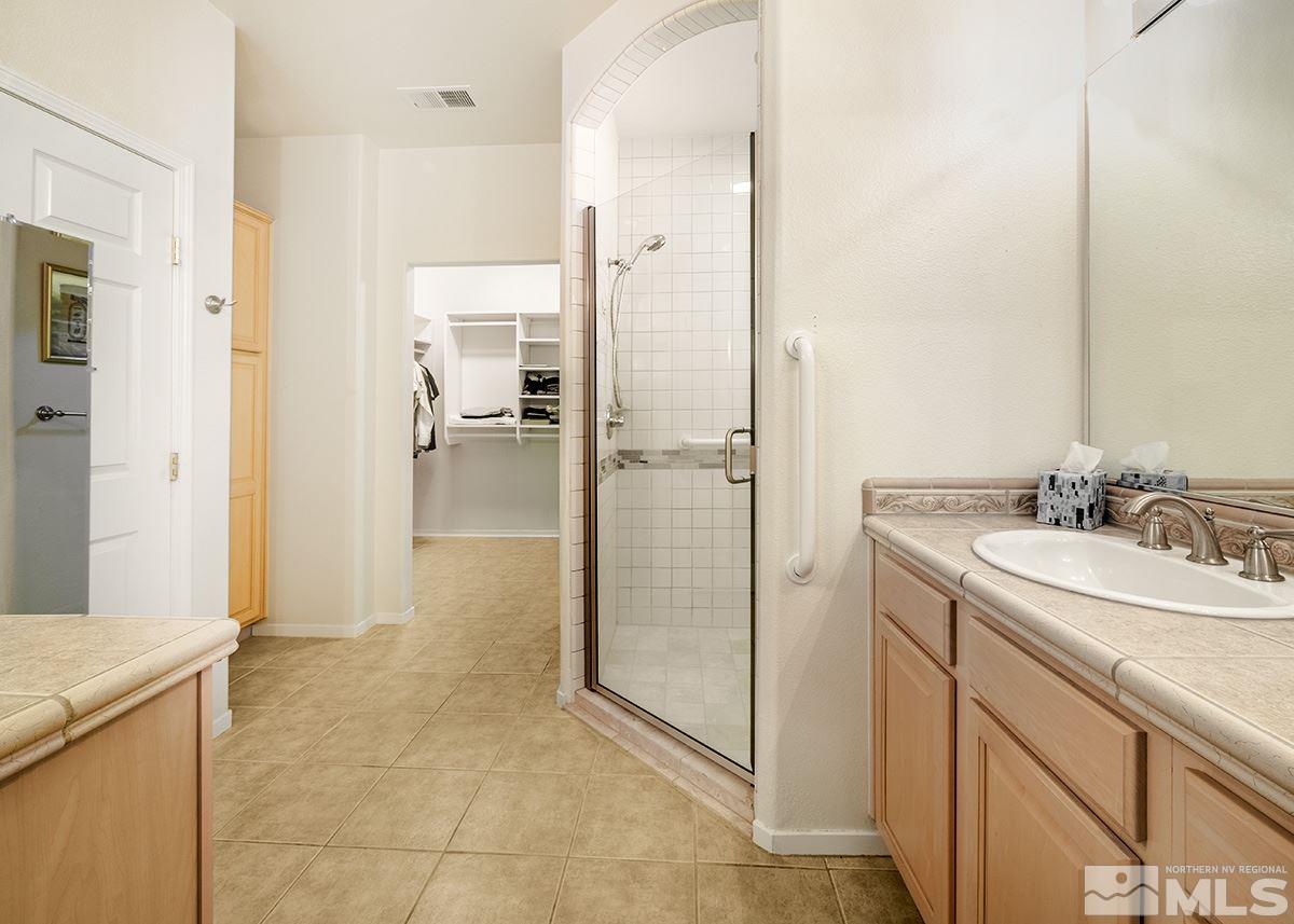 1408 Wild Wolf Way Reno, NV 89521 - Photo 16 of 24 a bathroom with a granite countertop sink mirror and shower
