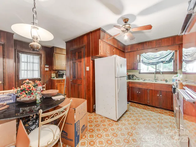 a kitchen with stainless steel appliances granite countertop a refrigerator a sink dishwasher with a dining table and chairs