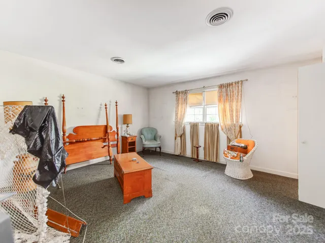 a living room with furniture a rug and white walls