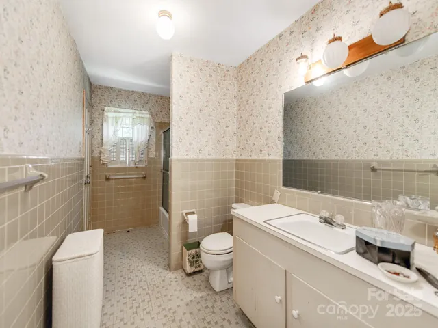 a living room with furniture a chandelier and a bookshelf