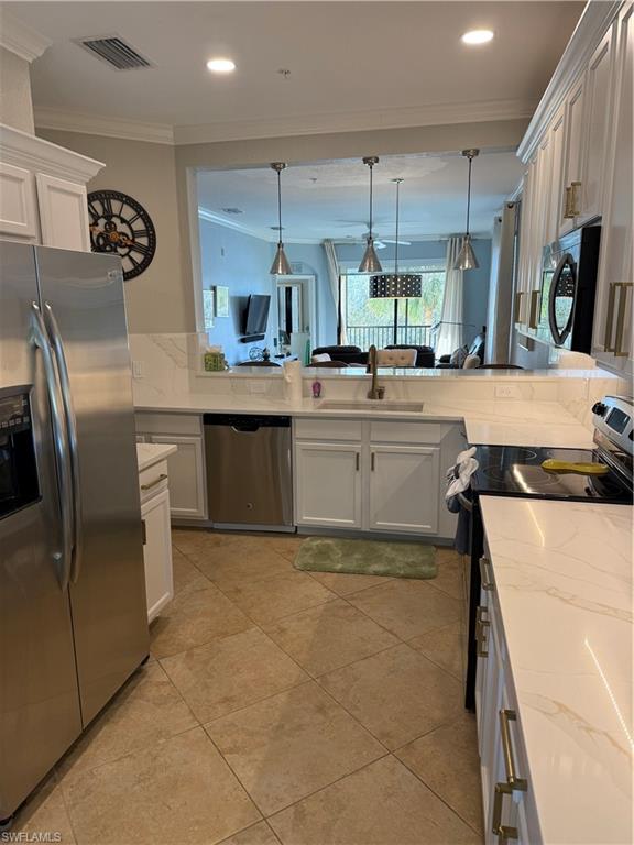 9719 Acqua Court, Unit 238 Naples, FL 34113 - Photo 15 of 25 a kitchen with stainless steel appliances granite countertop a sink and a refrigerator