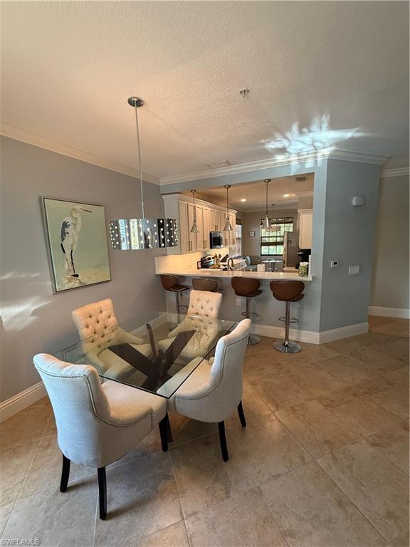 9719 Acqua Court, Unit 238 Naples, FL 34113 - Photo 17 of 25 a living room with a couch and chandelier