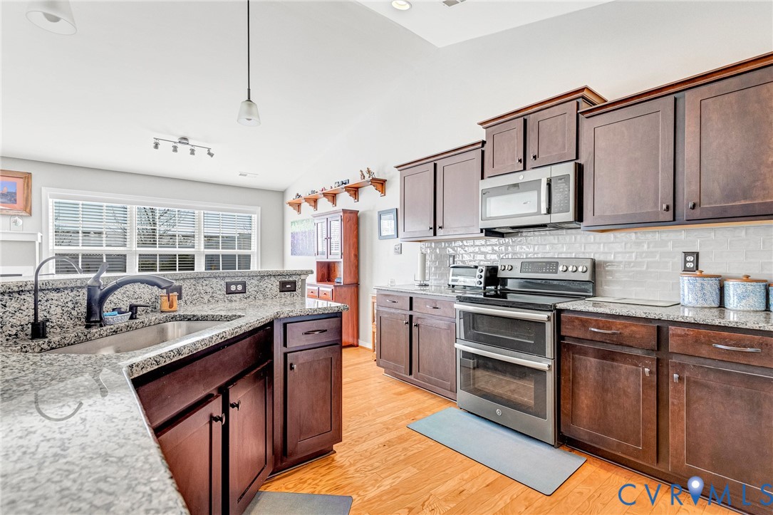 7401 Leaf Fall Way Mechanicsville, VA 23111 - Photo 17 of 48 a kitchen with stainless steel appliances granite countertop a stove a sink dishwasher and a refrigerator