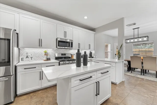 a kitchen with appliances a sink and cabinets
