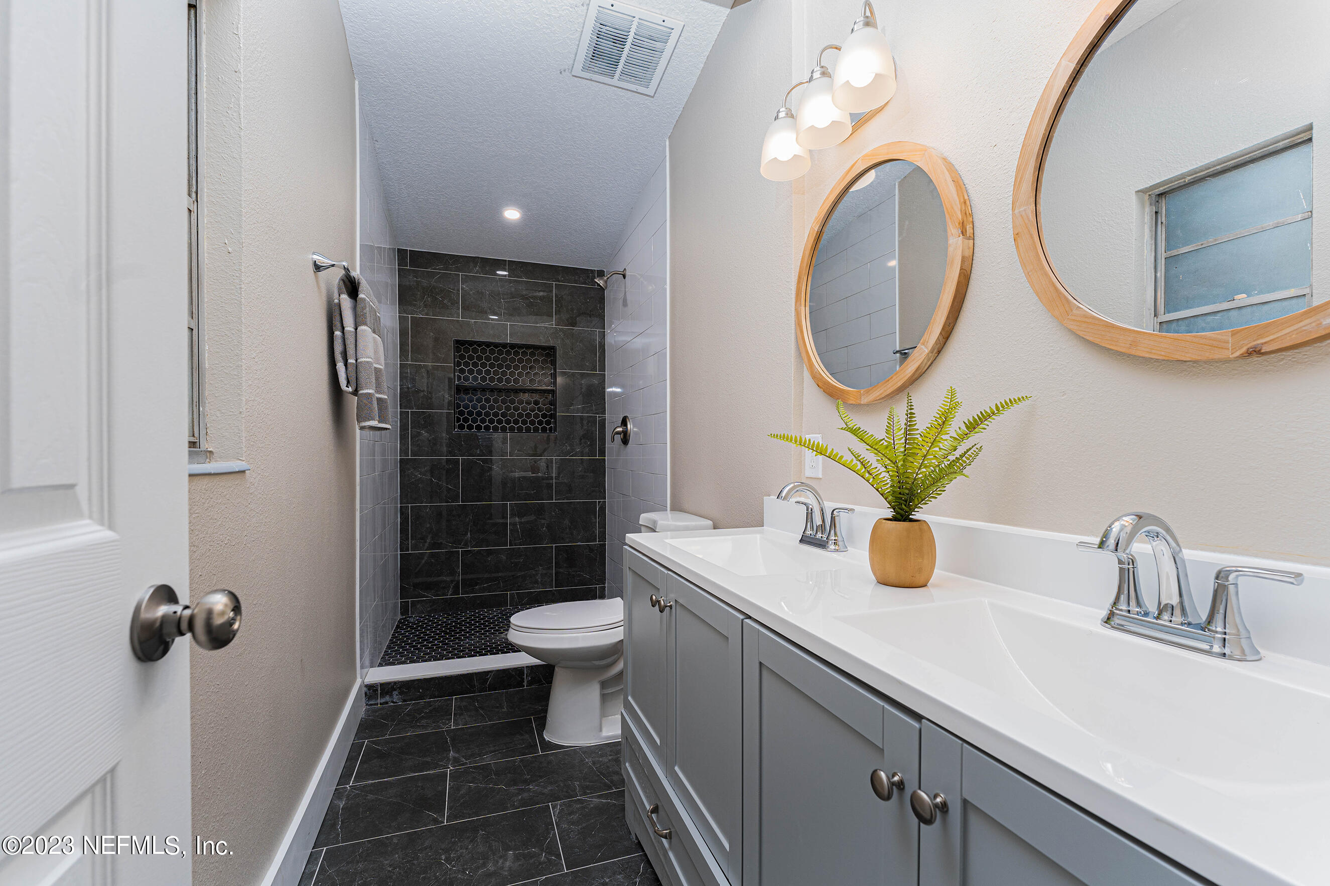 939 Westgate Drive Jacksonville, FL 32221 - Photo 13 of 31 a bathroom with a sink a mirror a toilet and shower