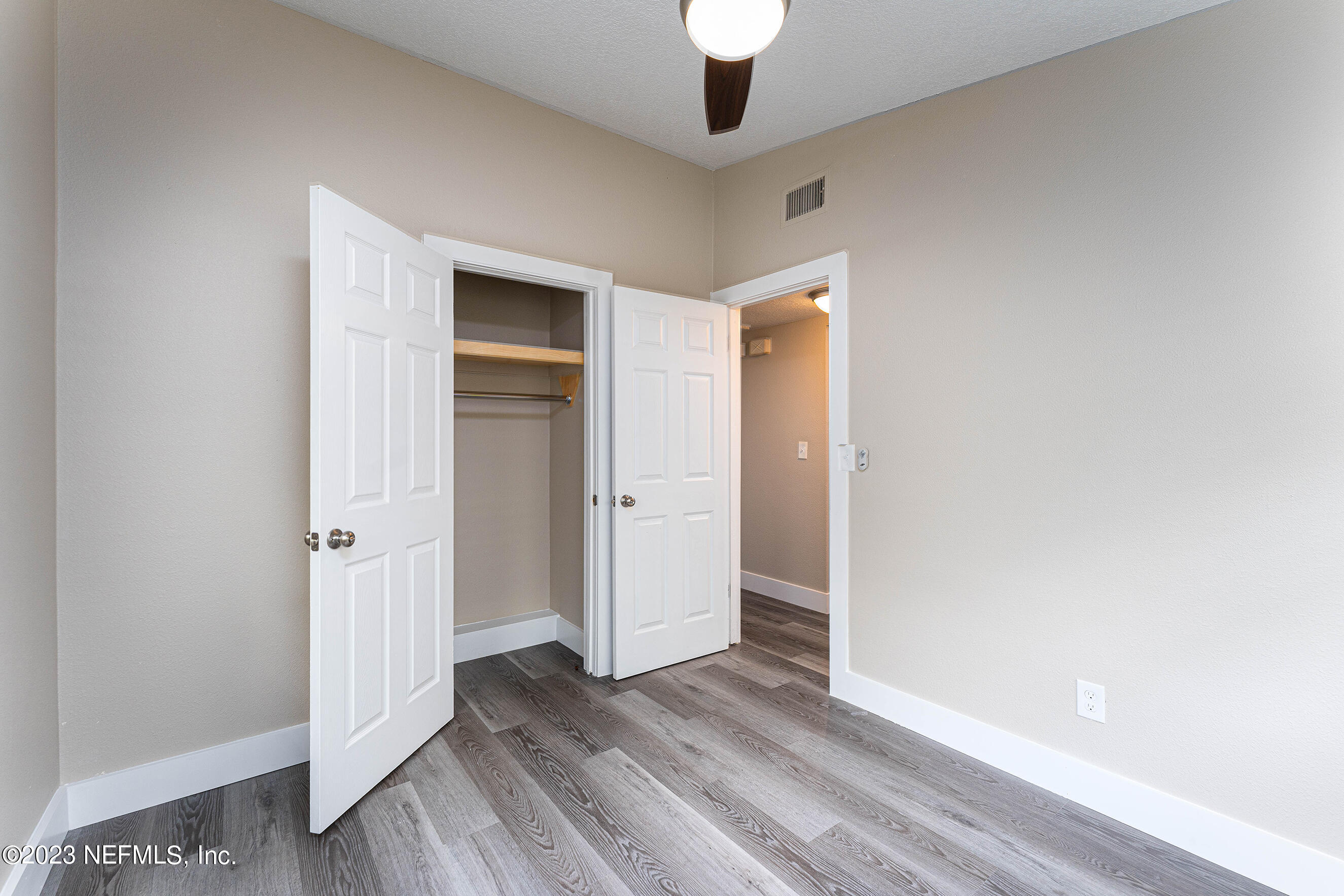 939 Westgate Drive Jacksonville, FL 32221 - Photo 21 of 31 an empty room with wooden floor and chandelier fan