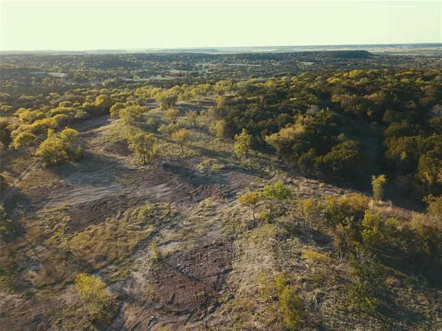 an aerial view of residential houses with outdoor space and trees