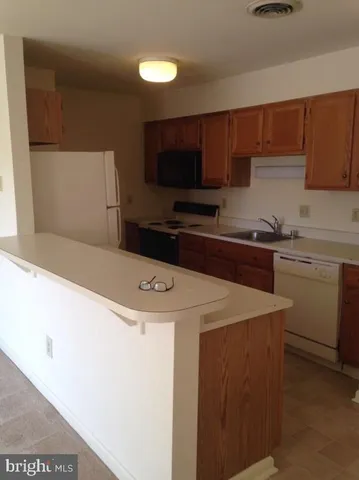 a kitchen with a sink a stove and cabinets