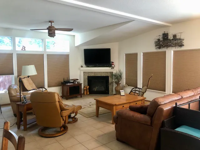a living room with furniture a flat screen tv and a fireplace