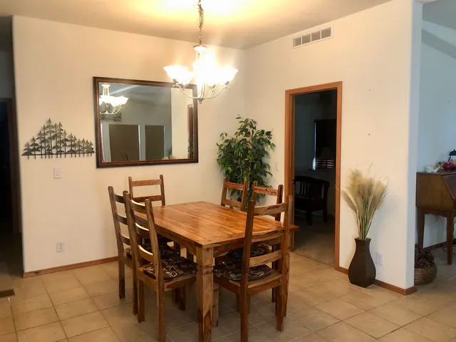 a view of a dining room with furniture and chandelier