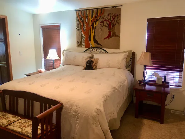 a bed sitting in a bedroom next to a window