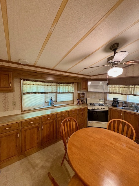 21-244 Woodhaven Sublette, IL 61367 - Photo 19 of 28 a kitchen with stainless steel appliances wooden cabinets a sink and a stove